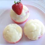 delicious white chocolate strawberry cupcakes on a white plate with fresh strawberry on top