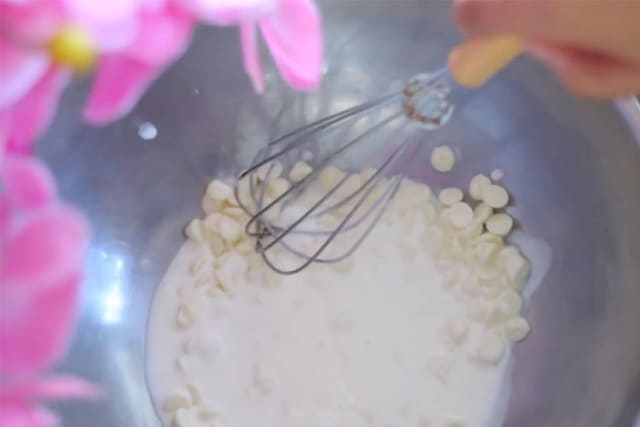melting the mini white chocolate chips in a bowl using a whisk
