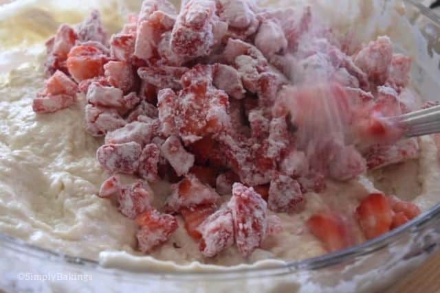 folding in the fresh strawberries to the cake batter