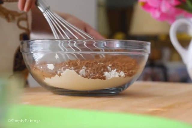 mixing the dry ingredients of milk chocolate cake in a glass bowl