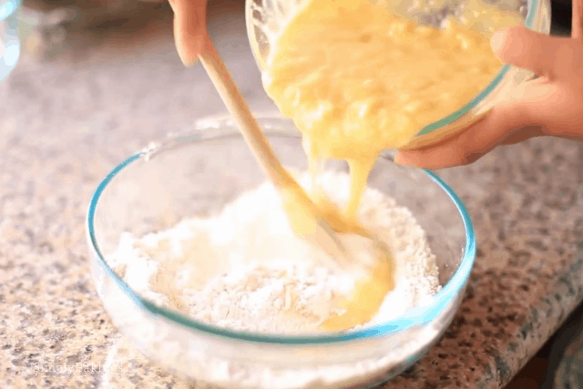 pouring the wet ingredients to the dry ingredients of the best mini banana muffin recipe