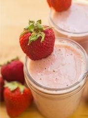Pink smoothie with evaporated milk at the table