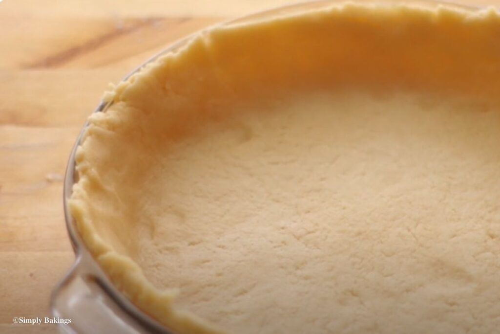 A pie pan wrapped with uncooked crust