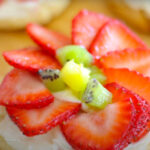 mini fruit pizza with cream cheese filling and strawberries and kiwi.