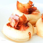 vegan donuts topped with vegan bacon on a white plate