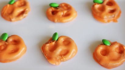 pumpkin chocolate covered pretzels on white plate