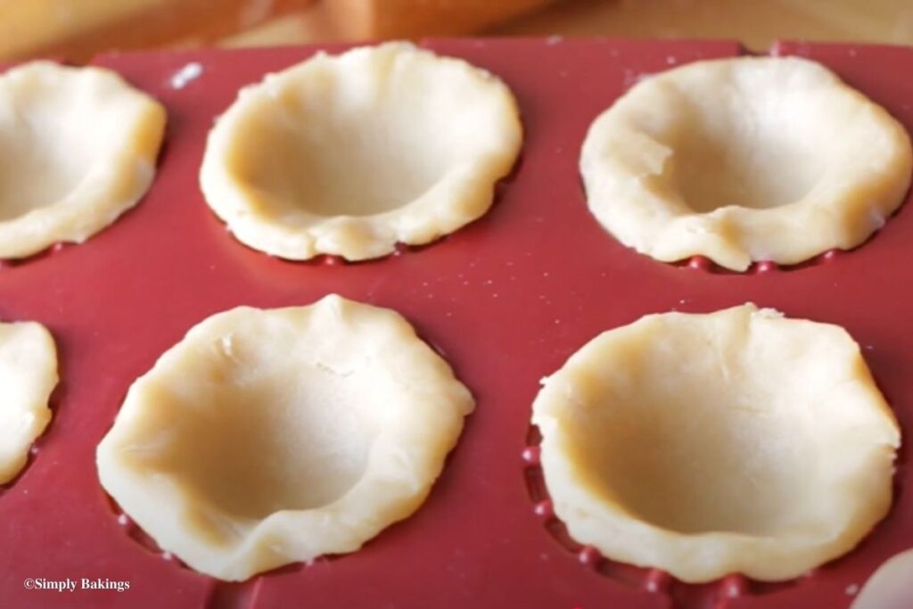 Baking sheet filled with small pie dough
