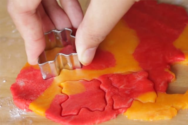 cutting leaf shapes out of the colorful cookie dough