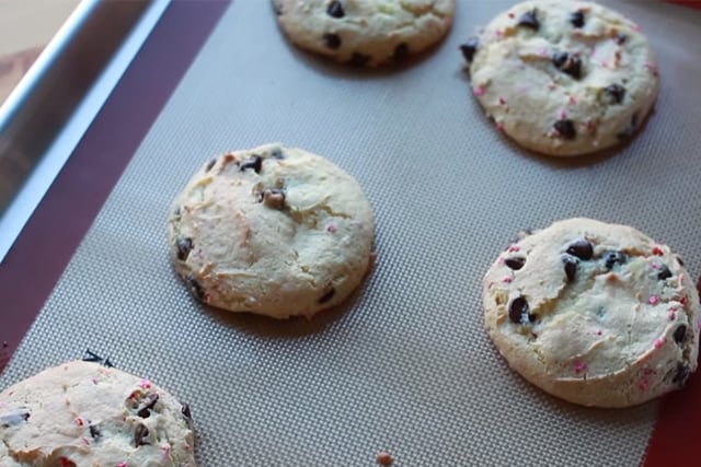 freshly baked chocolate chip cake batter cookies on a baking mat