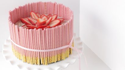 strawberry pocky cake on a cake stand