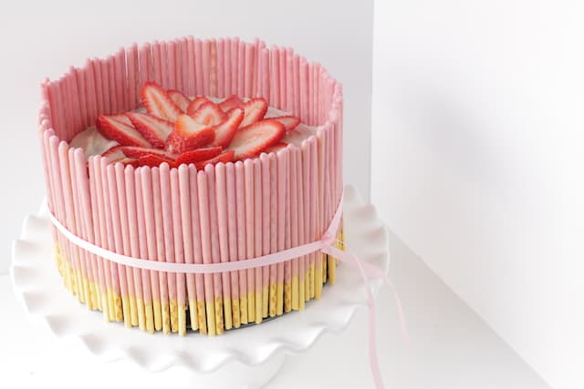 strawberry pocky cake on a cake stand