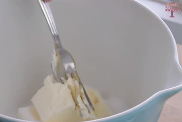 mixing butter and sugar in a bowl using a fork