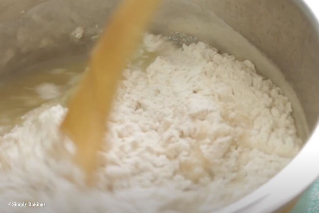 Mixing flour into a pan with other ingredients