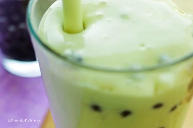 pouring the avocado milk shake into a glass with cooked boba