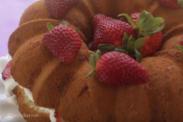 topping the cake with fresh strawberries