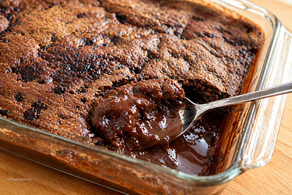 Hot Fudge Chocolate Cake in a glass pan with a spoon