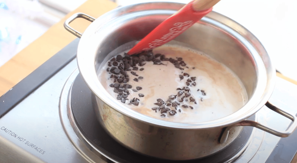 chocolate chips added to milk mixture in saucepan
