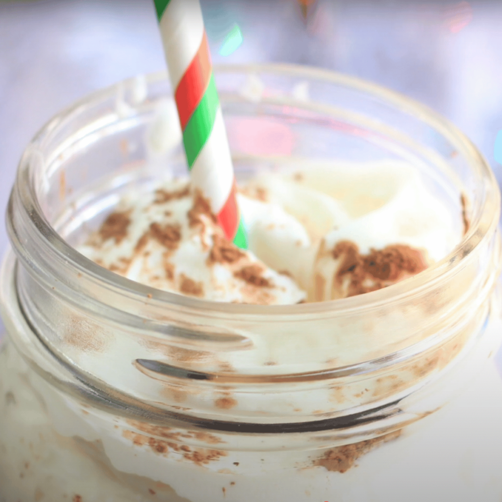 drink with whipped cream and cinnamon powder in a jar