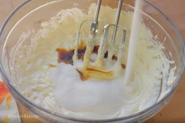 mixing the cream cheese, sugar and vanilla using a handheld mixer