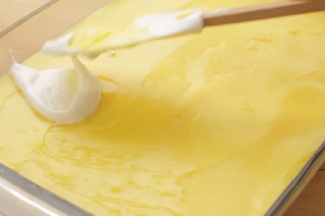 adding cream mixture on top of the custard layer using a rubber spatula