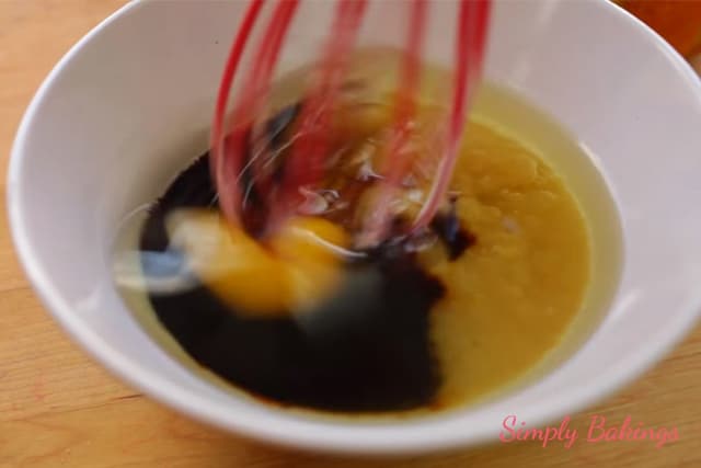 mixing the vanilla, canola oil and eggs using a wire whisk