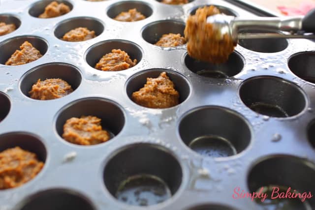 scooping the gingersnap cream cookie cups into mini muffin tray