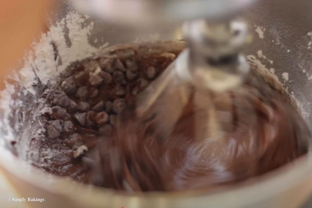 Adding more chocolate chips into the bowl
