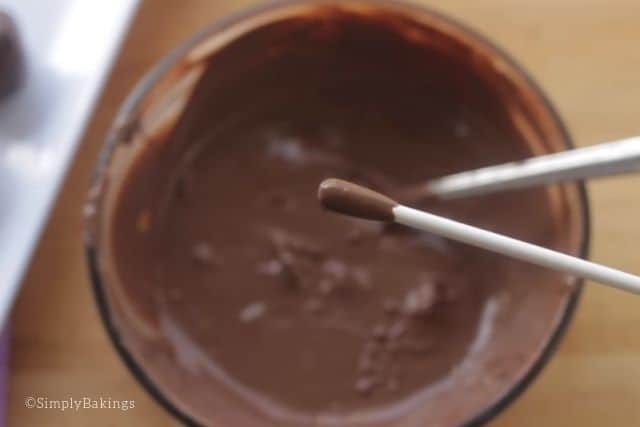coating the tip of the stick with melted chocolate
