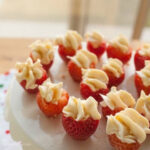 delicious Strawberry Stuffed Cheesecake Bites on a cake stand