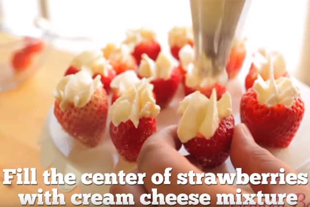 filling the center of strawberries with cream cheese mixture