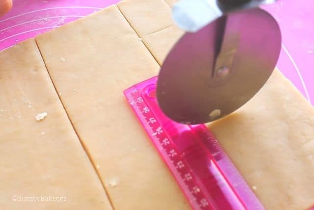 cutting the dough with a pizza cutter and measuring it with a ruler
