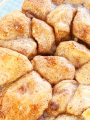 cinnamon rolls in a glass container on a cloth