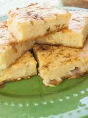 Slices of warm bibingka served on a vibrant green plate.