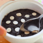 getting a piece of chocolate cookie in a mug using a spoon