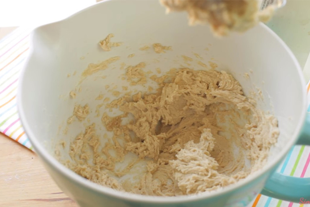 creaming butter and brown sugar in a blue mixing bowl