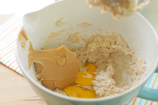 adding eggs, vanilla and peanut butter to the butter and sugar mixture