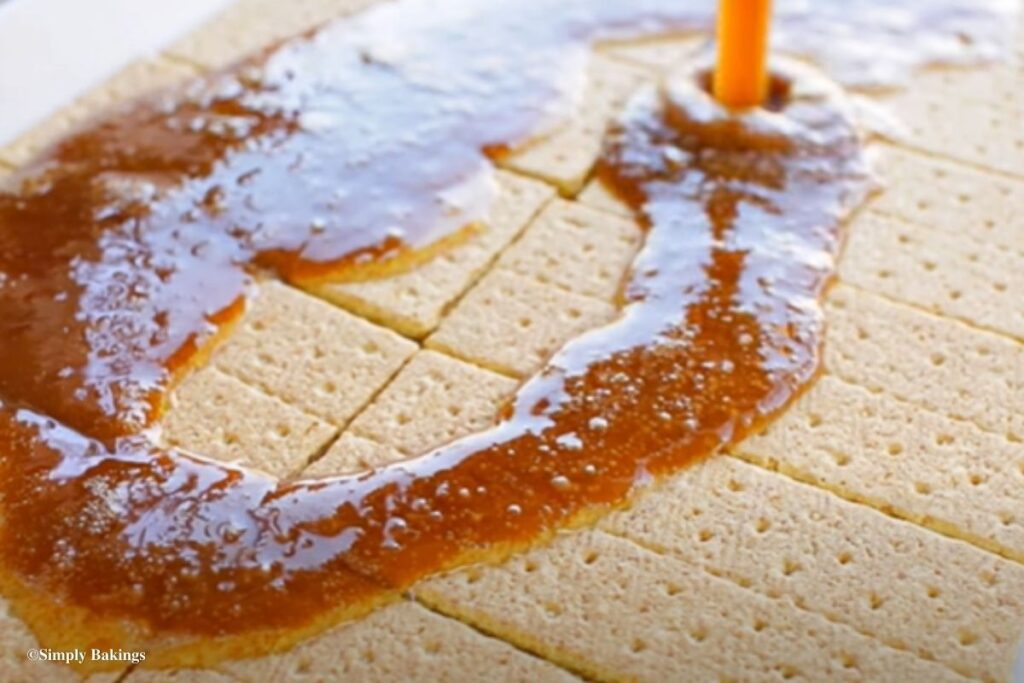 Spreading caramel all over the crackers