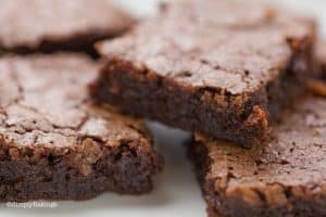 easy chewy brownies stacked on a white plate
