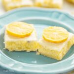 two lemon brownies with lemon glaze on a small light blue plate