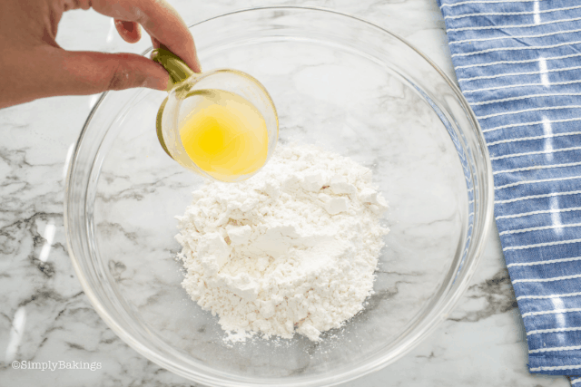 pouring lemon juice to powdered sugar to make lemon glaze