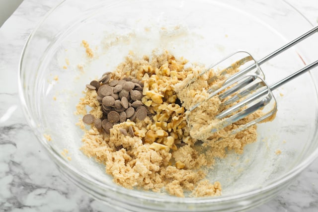 mixing carob chocolate chips and walnuts to the vegan blondies batter