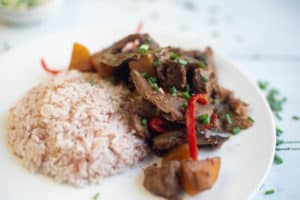 delicious vegetarian Filipino Chicken Adobo with brown rice on a white plate