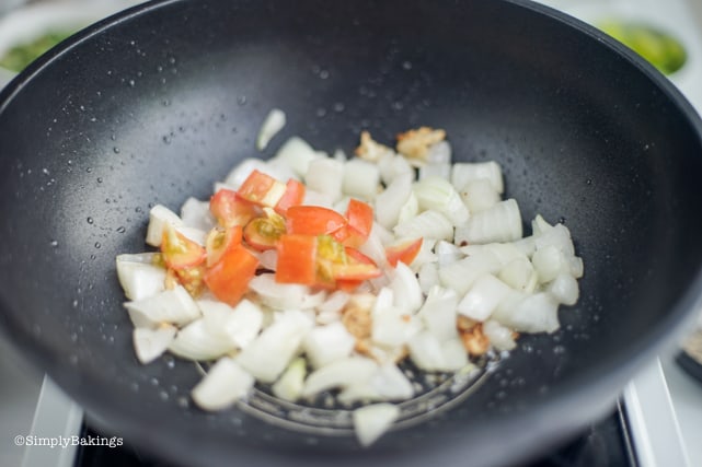 sauteing tomatoes with the onion and garlic in the pan