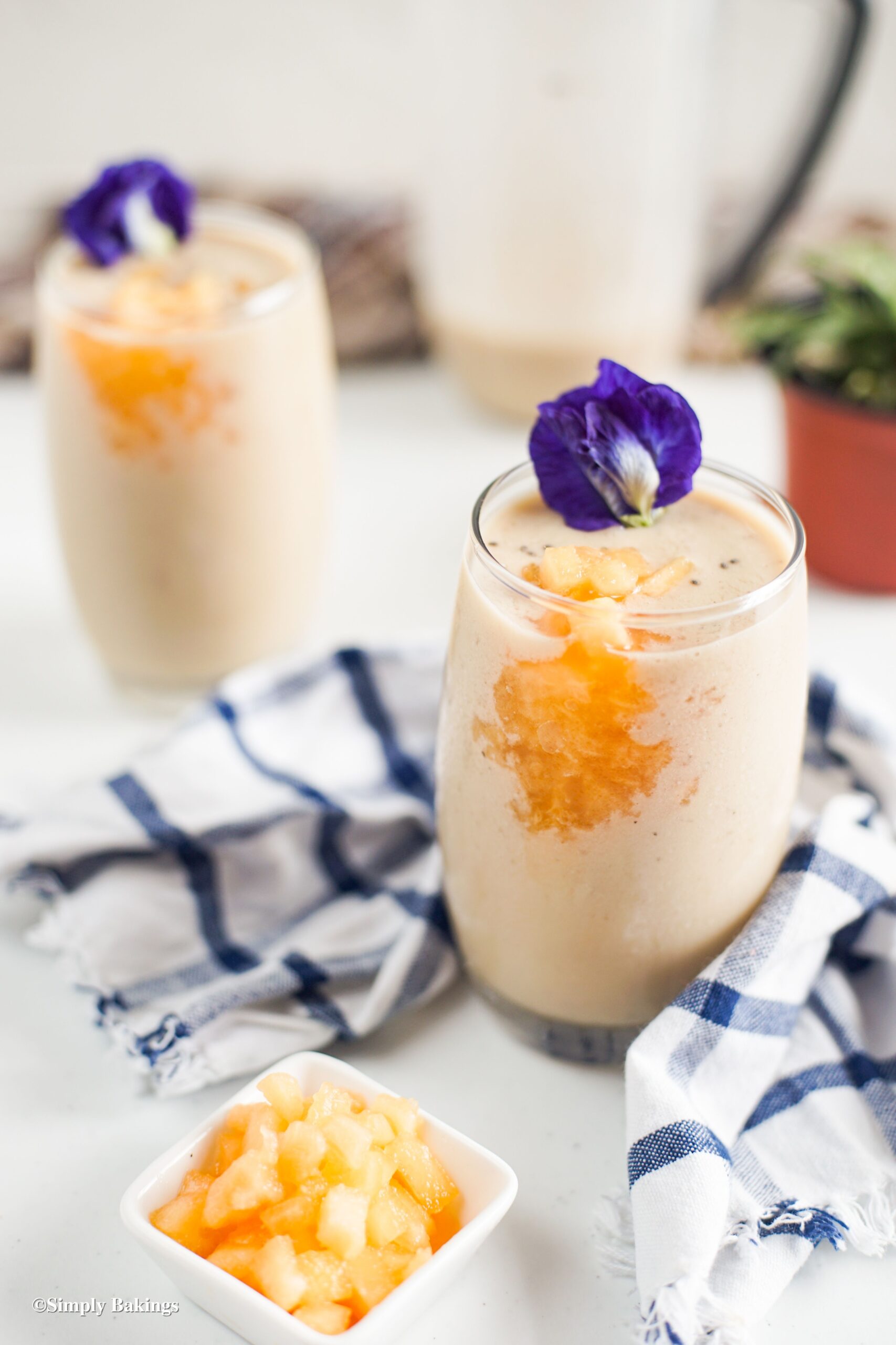 Two smoothies in glasses with flower on top