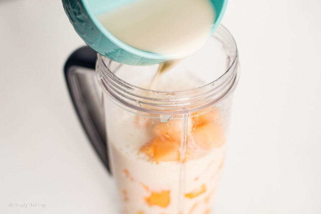 Blender filled up with soy milk from bowl