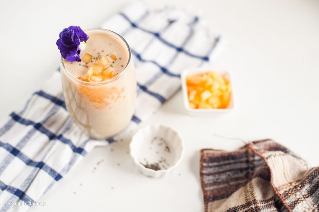A glass of cantaloupe smoothie sprinkled with seeds