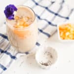 cantaloupe smoothie in a glass with chia seeds and pineapple chunks