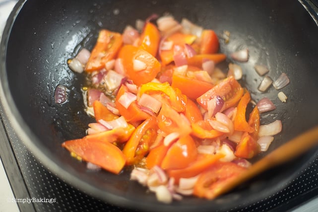 sauteing tomatoes and onions on a pan 