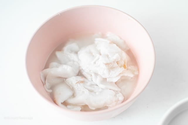slices of young coconut meat in a pink bowl