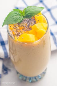 delicious and fresh banana mango smoothie in a glass with mint leaves